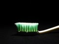 A unique picture of a toothbrush under dark background.