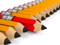 Unique red wooden pencil with eraser standing out from the orange crowd on white background. Isolated 3D illustration Royalty Free Stock Photo