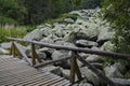 Unique stone river with big granite stones or moraine and wooden bridge Royalty Free Stock Photo