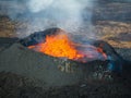 Erupted volcano and surroundings, boiling lava flowing, pull away drone shot