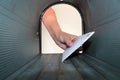 A Unique view of someone getting or placing mail in a mail box, shot from the Inside Out