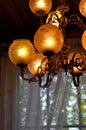 Unique vintage chandelier or hanging ceiling lamp with many light bulbs. Metallic intricate frame with many round glass lampshades Royalty Free Stock Photo