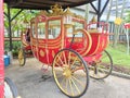 a unique and vintage photo of the royal golden train of Indonesian history in red in the garden taken in the afternoon