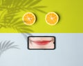 Unique wallpaper concept combining a fresh orange cut and smartphone image with lovely smiling lips.