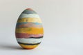 A uniquely painted Easter egg in bold tempera colors stands out on a pristine white background Royalty Free Stock Photo