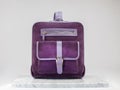 Luxury suet backbag. Luxury purple leather and suet backpack on white background, on marble floor.