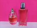 Unisex bottles of perfume on a pink and white background Royalty Free Stock Photo