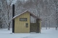 Unisex outhouse in a snowy campground