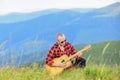 In unison with nature. Musician hiker find inspiration in mountains. Keep calm and play guitar. Man with guitar on top Royalty Free Stock Photo