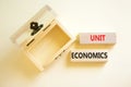 Unit economics symbol. Concept words Unit economics on wooden blocks. Beautiful white table white background. Wooden empthy chest