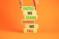 United or divided symbol. Concept words United we stand divided we fall on wooden blocks. Beautiful orange table orange background Royalty Free Stock Photo