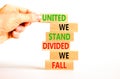 United or divided symbol. Concept words United we stand divided we fall on wooden blocks. Beautiful white table white background. Royalty Free Stock Photo