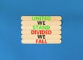 United or divided symbol. Concept words United we stand divided we fall on wooden stick. Beautiful blue table blue background. Royalty Free Stock Photo