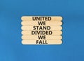 United or divided symbol. Concept words United we stand divided we fall on wooden stick. Beautiful blue table blue background. Royalty Free Stock Photo