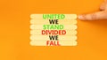 United or divided symbol. Concept words United we stand divided we fall on wooden stick. Beautiful orange table orange background Royalty Free Stock Photo