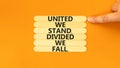 United or divided symbol. Concept words United we stand divided we fall on wooden stick. Beautiful orange table orange background Royalty Free Stock Photo