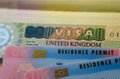 United Kingdom BRP Biometrical Residence Permit cards for Tier 2 work visa placed on top of UK VISA sticker in the passport. Clo