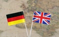 The United Kingdom and Germany flag pins on a world map background, political relations concept Royalty Free Stock Photo