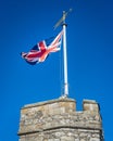 United Kingdom Union Jack flag blowing in the wind on top of Westgate Towers, Canterbury, England. Royalty Free Stock Photo