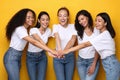 United Multiracial Ladies Holding Hands Standing Together, Yellow Background