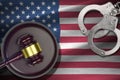 United States of America flag with judge mallet and handcuffs in dark room. Concept of criminal and punishment