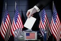 United States of America flags, hand dropping ballot card into a box - voting, election concept Royalty Free Stock Photo