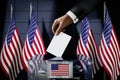 United States of America flags, hand dropping ballot card into a box - voting, election concept Royalty Free Stock Photo