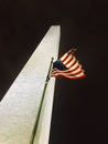 United States of America USA flag in front of lit up Washington monument at night from below Royalty Free Stock Photo