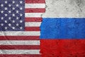 United States of America vs Russia - Cracked concrete wall painted with a USA Americas flag on the left and a Russian flag on the