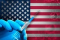 United States Covid-19 Vaccination Campaign. Hand in a blue rubber glove holds a syringe with covid-19 virus vaccine in front of Royalty Free Stock Photo