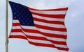 United States flag blows in the wind against a sky