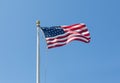 The United States flag on blue sky background, turned to the right Royalty Free Stock Photo