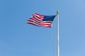 The United States flag on blue sky background, turned to the right Royalty Free Stock Photo