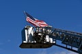 United States flag flies from a fire truck ladder.