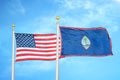 United States and Guam two flags on flagpoles and blue cloudy sky