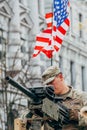 United States Marine Corps soldier on the top of a military vehicle mounting a machine gun with American flagAmerican flag Royalty Free Stock Photo