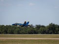 United States Navy Blue Angel fighter jet flying low over an airport during an airshow in Florida Royalty Free Stock Photo