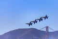 United States Navy Blue Angels aerobatic team's F-18 Hornet combat jets in flight over Golden Gate Bridge, San Francisco