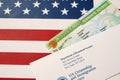 United States Permanent resident green card from dv-lottery lies on United States flag with envelope from Department of Homeland Royalty Free Stock Photo