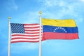 United States and Venezuela two flags on flagpoles and blue cloudy sky