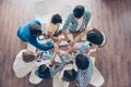 Unity and connection of people. Topview of partners putting their hands together, they sit at nice workstation, wearing casual cl