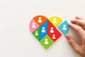 Unity and diversity partnership concept. heart shaped puzzle and group of diverse miniature people connected