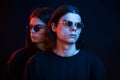 Unity of people. Portrait of twin brothers. Studio shot in dark studio with neon light