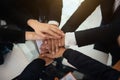 Close up top view of young business people putting their hands together.