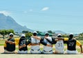 Unity always wins. Rearview shot of a team of unrecognizable baseball players embracing each other while sitting near a