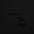 Universal black & white wrench isolated on black background