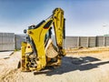 Universal excavator or loader with folded bucket at construction site. Universal construction equipment. Rental of construction