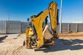 Universal excavator or loader with folded bucket at construction site. Universal construction equipment. Rental of construction Royalty Free Stock Photo