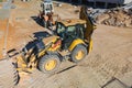 Universal excavator or loader with folded bucket at construction site. Universal construction equipment. Rental of construction Royalty Free Stock Photo