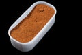 Universal seasoning mixture of pepper for marinating meat in a plastic vessel, on a black background, isolate